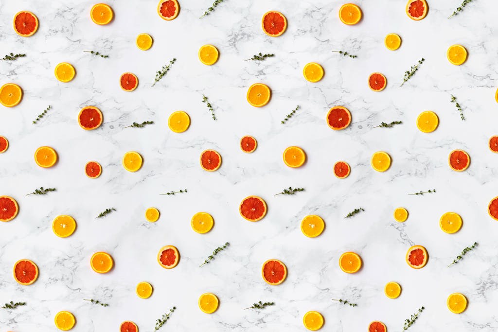 Colorful citrus slices arranged in a flat lay pattern on a marble surface, ideal for backgrounds.